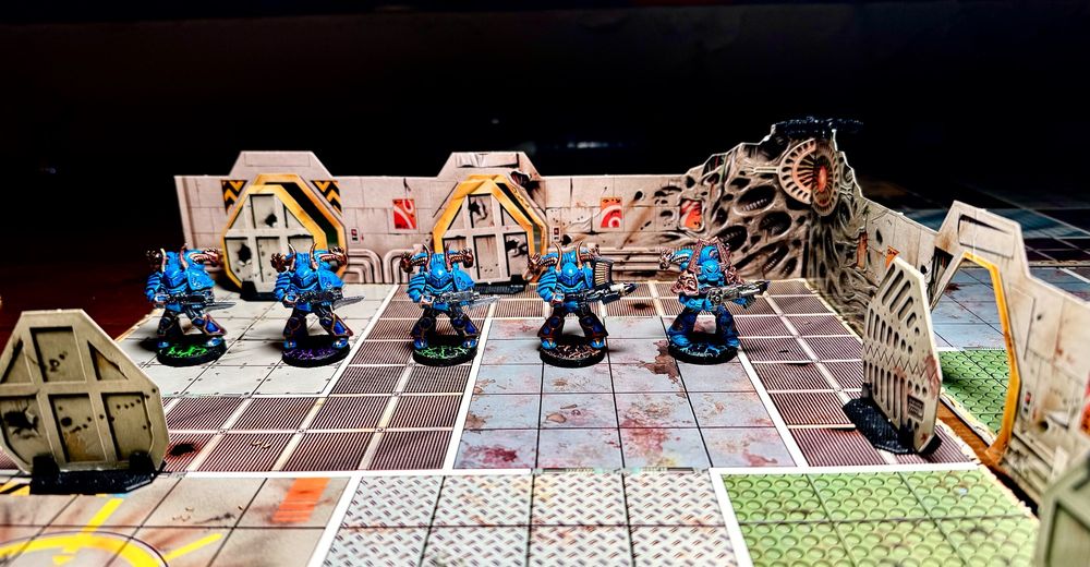 Five Chaos Marines squad laid on a square tile from the tabletop board game Space Crusade. 