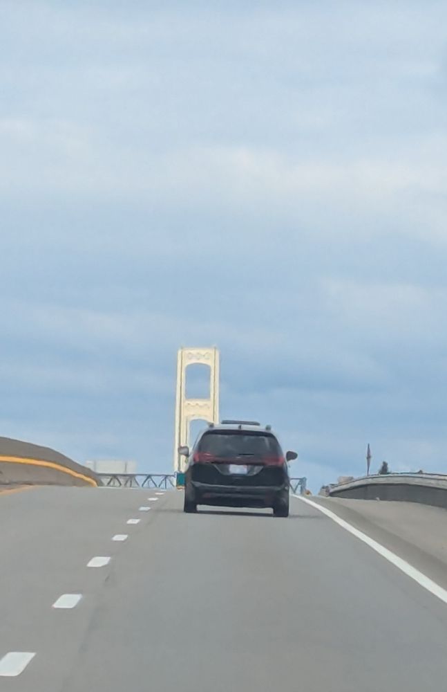 The South tower of the Mackinac Bridge against a partly cloudy sky
