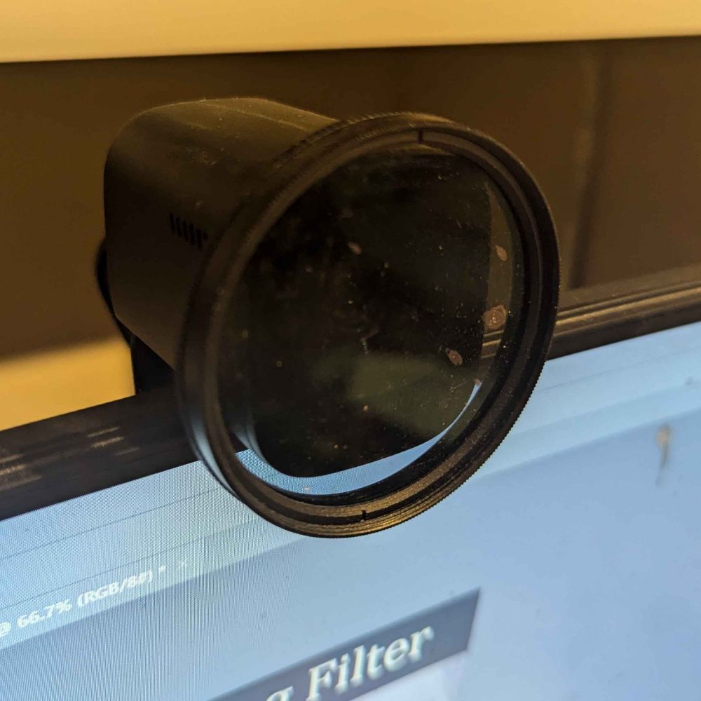 A webcam with a polarizing filter over the front of it.