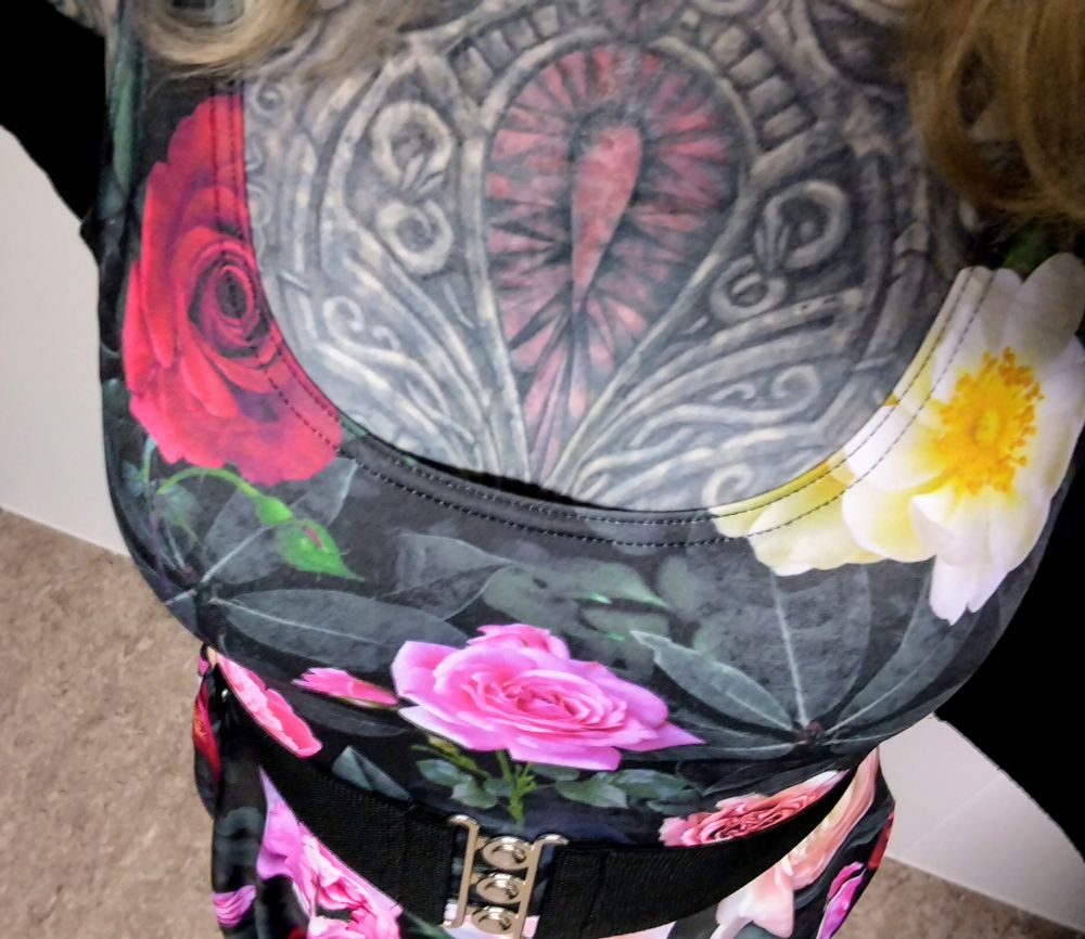my tattooed chest photographed at an angle from above showing how my boobs look in this scoop neck dress with roses print