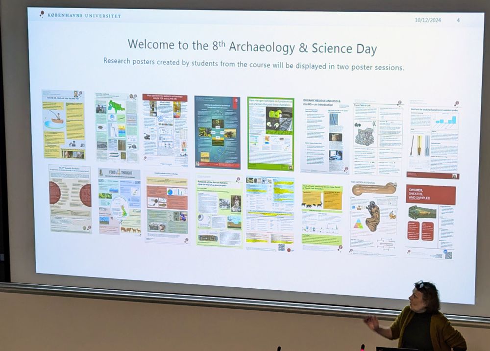 A projected slide shows a collection of 14 research posters arranged in two rows. The posters cover various archaeological topics, featuring colorful diagrams, maps, and images. The slide's header reads 'Welcome to the 8th Archaeology & Science Day' and indicates these are student research posters. A presenter in a brown cardigan stands at the bottom of the screen, gesturing toward the display. The date 10/12/2024 is visible in the top right corner.
