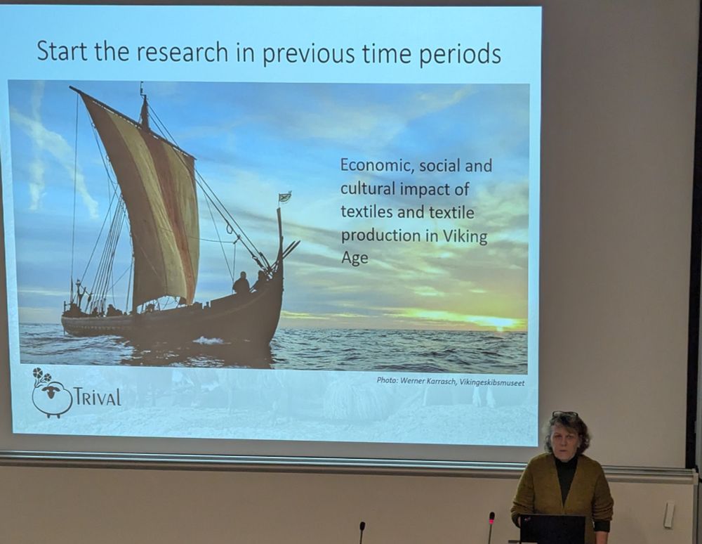 A presentation slide titled 'Start the research in previous time periods' showing a dramatic photograph of a Viking ship at sea against a sunset sky. The slide discusses the economic, social and cultural impact of textiles and textile production in the Viking Age. The TRIVAL project logo appears in the bottom left corner, with photo credit to Werner Karrasch, Vikingeskibsmuseet.