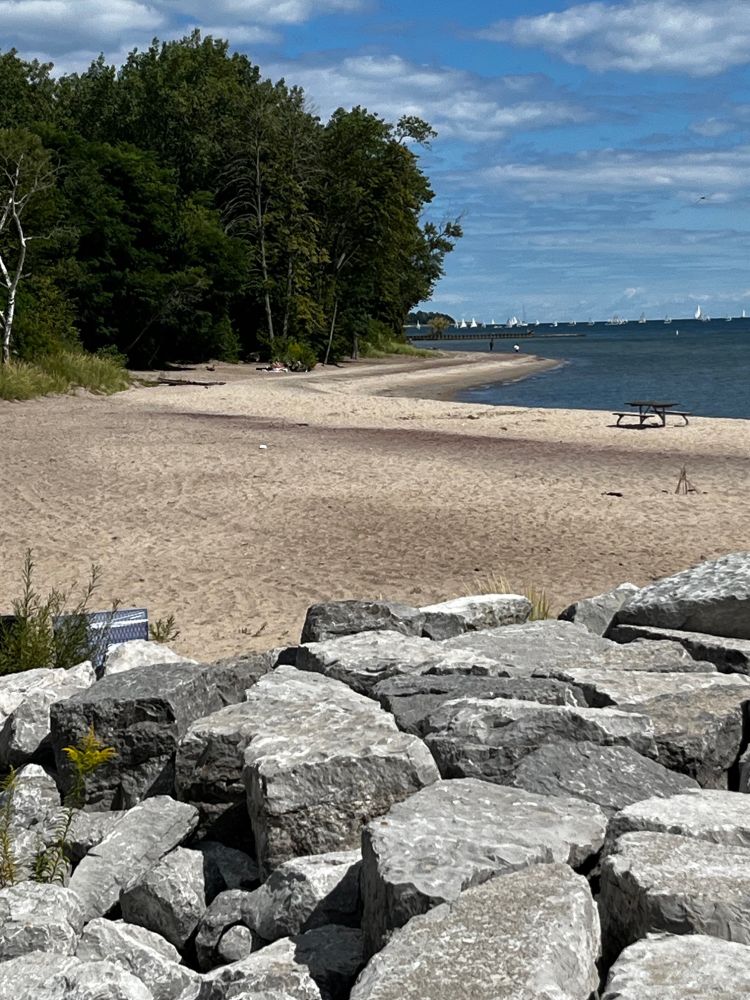 Sunny, sandy each with sailboats in the distance.