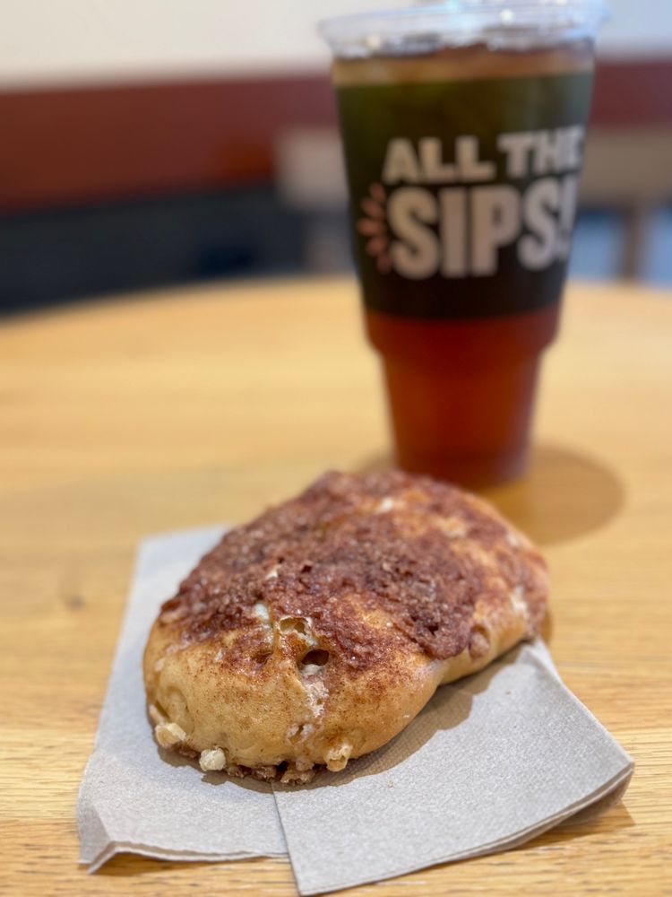 Photo of a bagel and iced tea on a table.