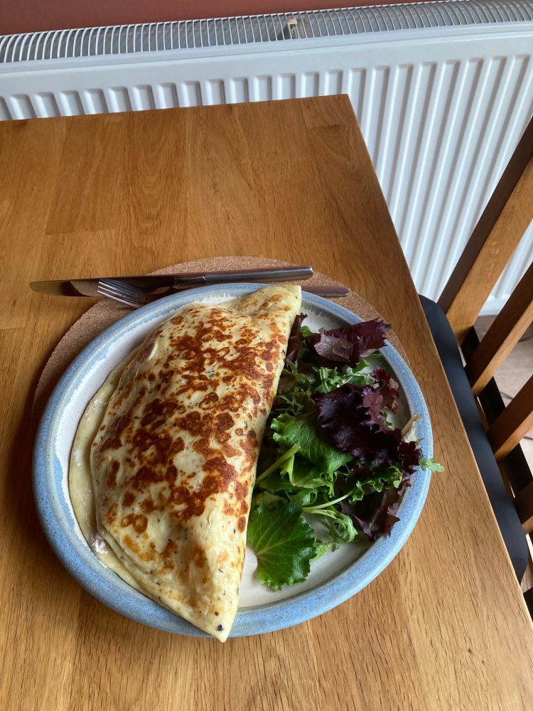 Savoury Pancake and salad on a plate on a table. 