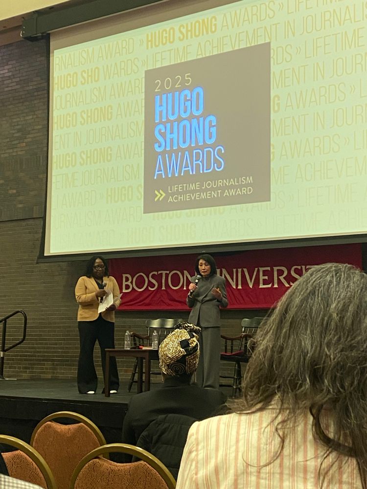 Connie Chung and Meghan Irons stand on stage in front of Boston university banner