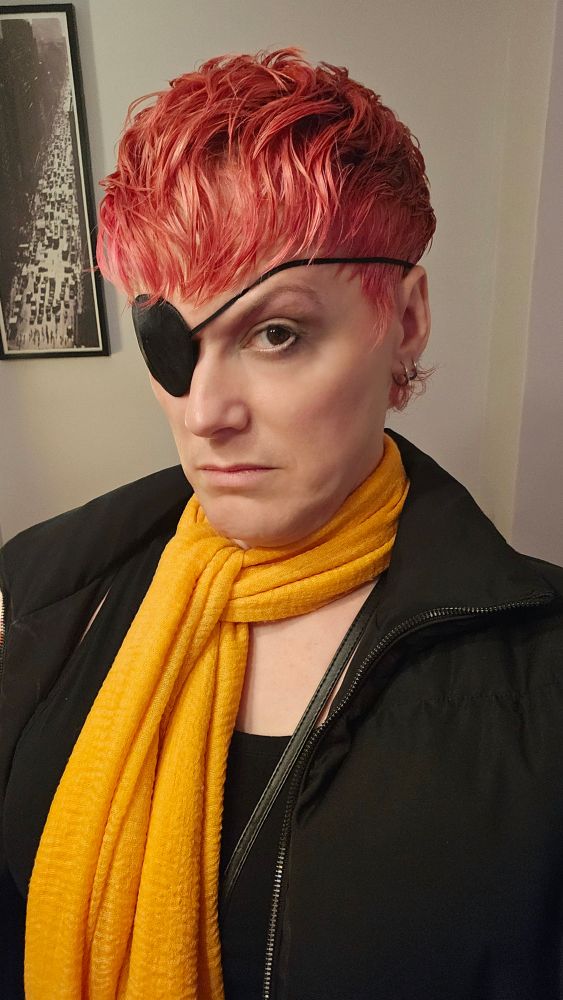 a woman with pink hair, yellow scarf, black bomber, and even witheringer scowler 😎