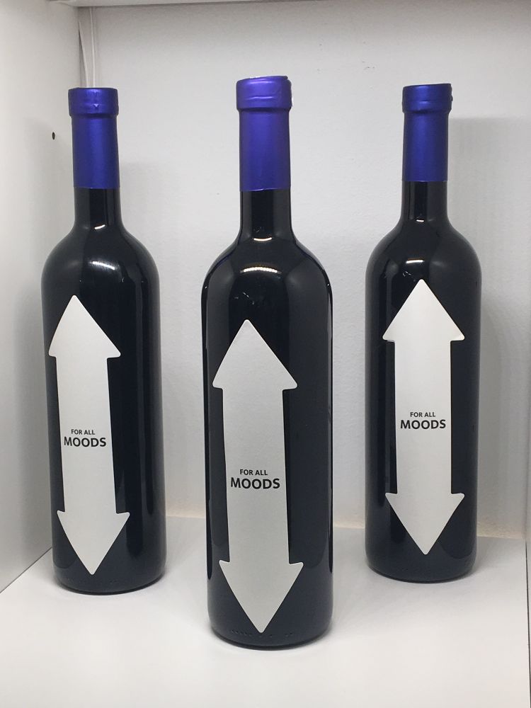 A picture of three wine bottles. The label on all three is the same: an arrow pointing up and down, For all MOODS written in the center.