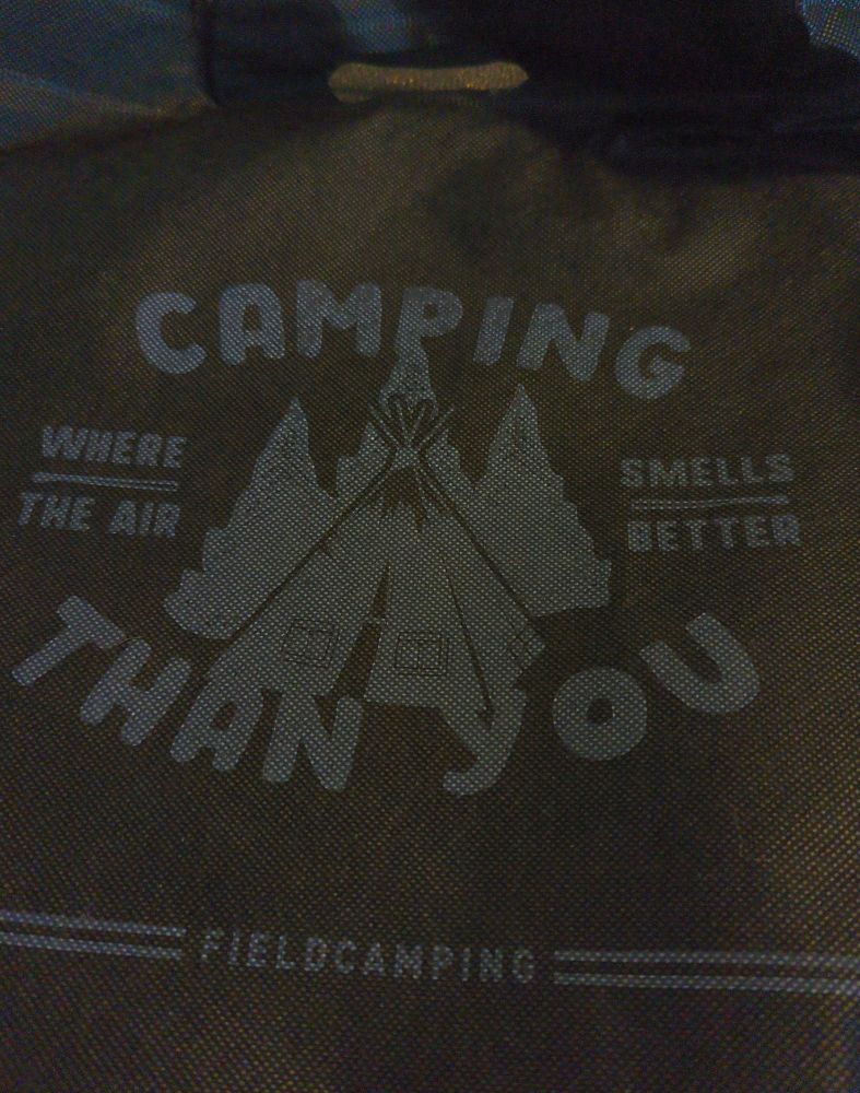 A small extremely cheap tote bag that says "camping where the air smells better than you"