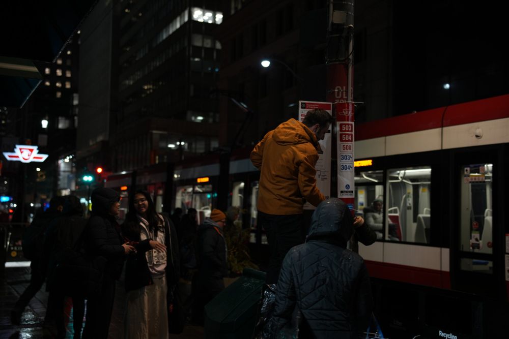 Group of volunteers hanging sign on TTC post