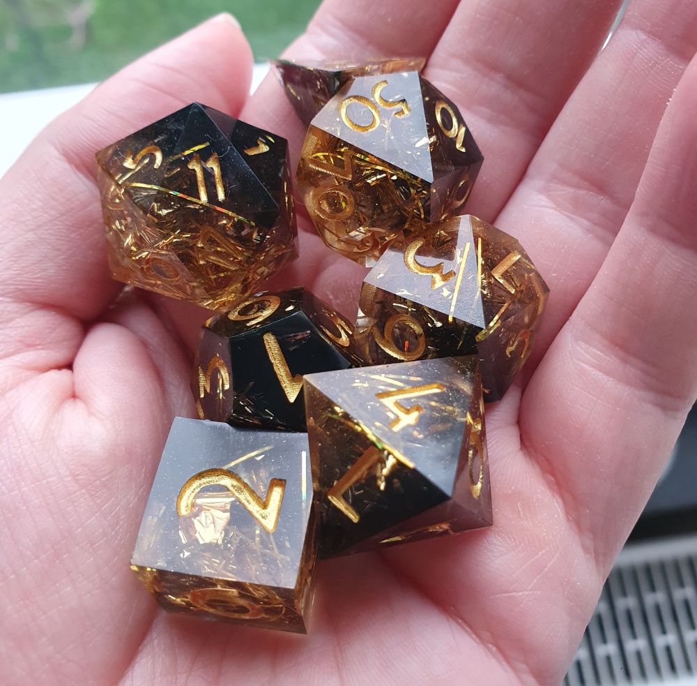 Gold and black dice for pen and paper with golden painted numbers.