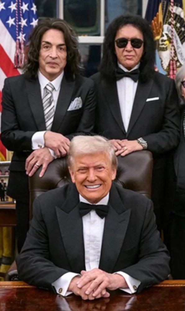 A photograph of Paul Stanley and gene Simmons from the band kiss standing behind Donald Trump in the oval office
