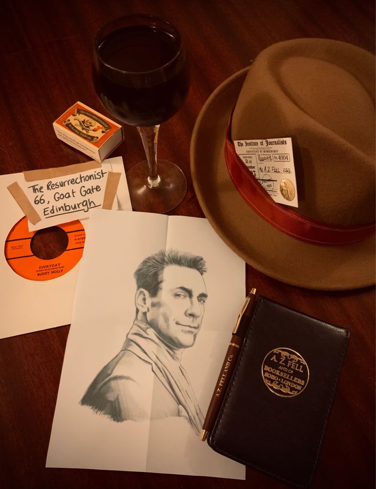 The accoutrements of an International Man(-shaped being) of Mystery. A Clue™️ in the shape of a copy of Mister Holly’s song, a glass of wine, a disguise (ace-reporter’s notebook and extremely jaunty hat), and a sketch of a Person of Interest.