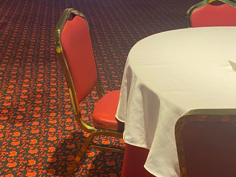 A red chair next to a white tablecloth, with a patterned red and black carpet below, recreating the now-closed Marigold yum cha restaurant in Sydney’s Chinatown 