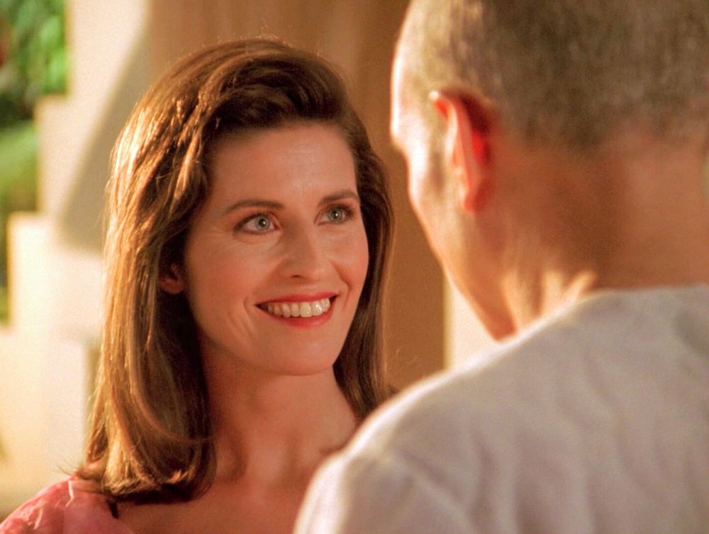 Vash smiling at Picard in her room at the hotel on Risa