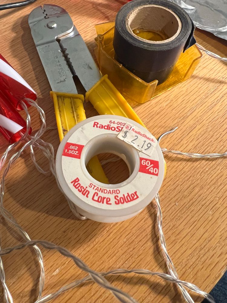 A spool of solder labeled as 2.19 from radio shack 