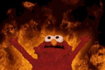 elmo from sesame street is standing in front of a fire