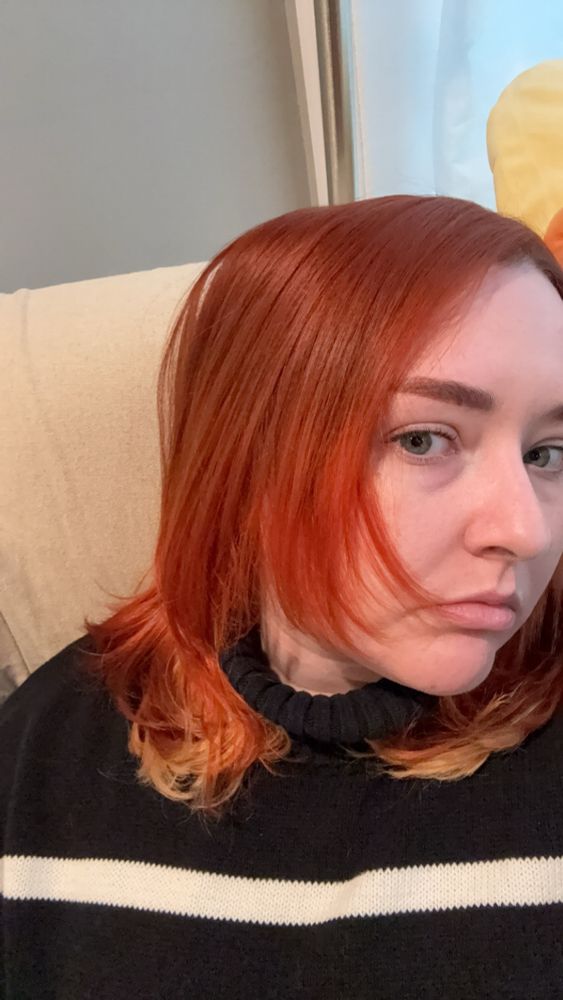 selfie of kris showing their hair which is bright orange with a blonde underlayer