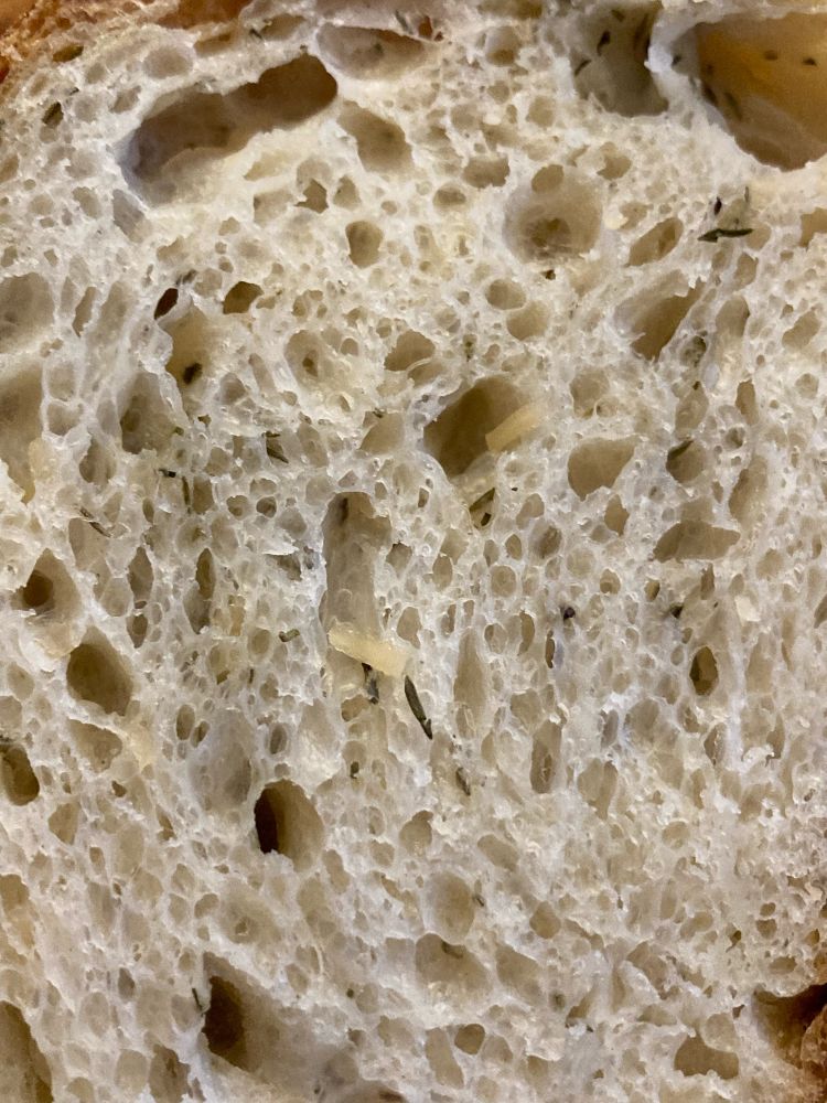 Close up of the crumb showing specs of dried thyme and aged Parmesan cheese