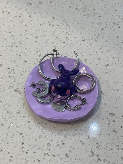 A little polymer clay trinket tray. It's a lavender color, and features the BTS borahae whale (a purple whale).