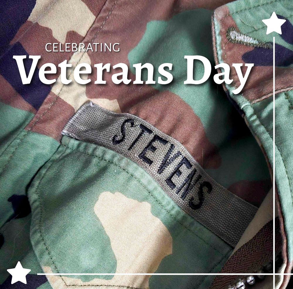 Photo of an old Army jacket, with the name "Stevens" attached to it. Overlaid are the words "Celebrating Veterans Day" with stars.