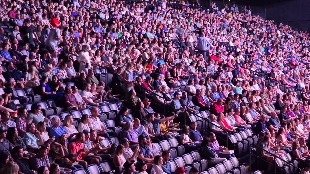 A large group of white people in arena seating.
