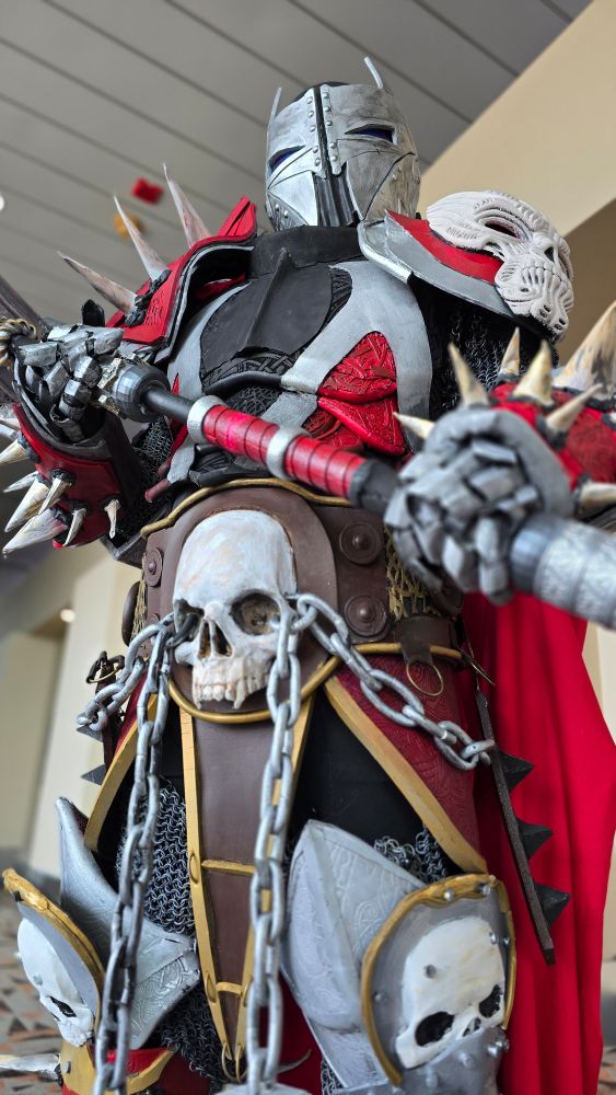 A man dressed as Medieval Spawn, carrying a hammer. 