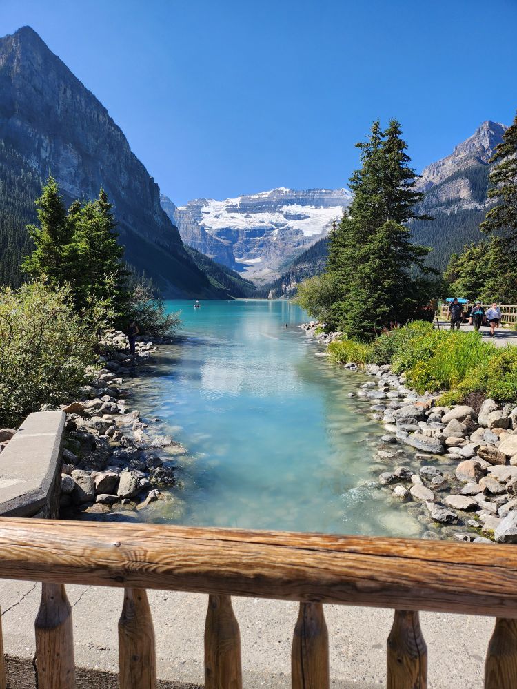 Cherrim isn't in this one, I just really liked the photo. It's a blue stream coming from the main lake with a rocky shore and trees framing the stream and the mountains in the background. There are kayakers in the distance and in the foreground is the ledge of a bridge overlooking it all. The water is so blue!!!