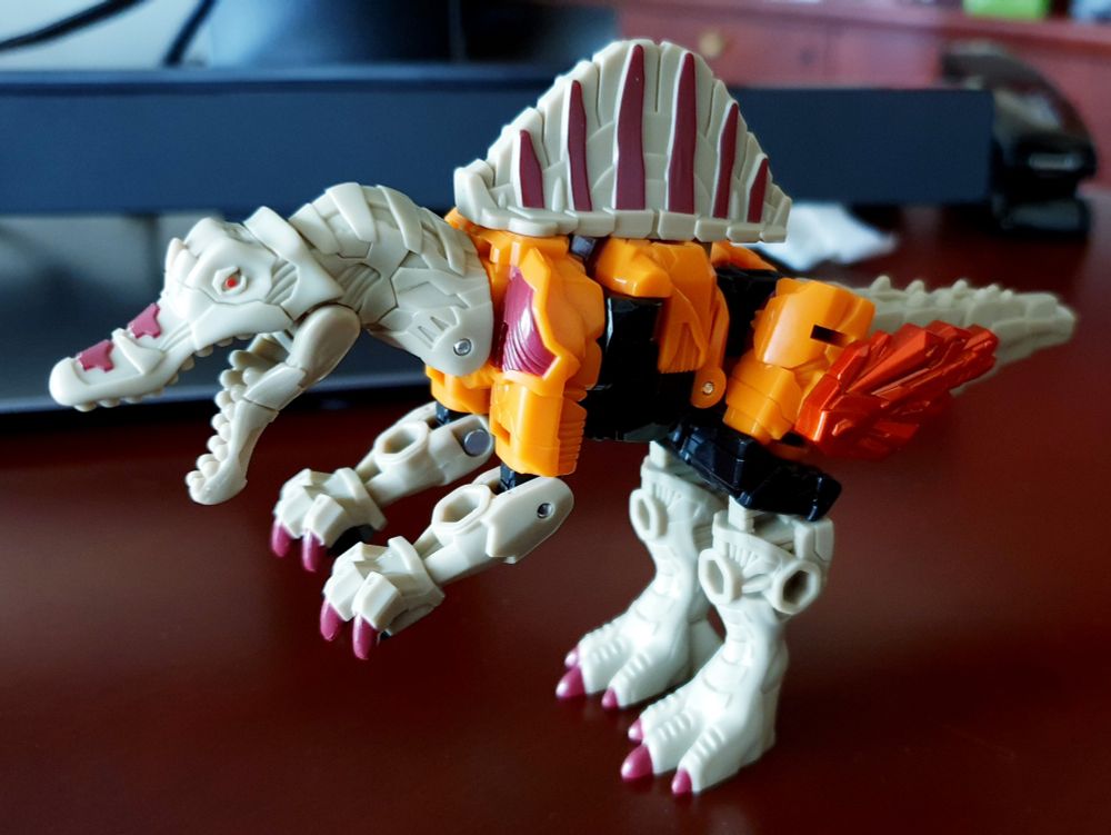 Transformers: Wild King Spirituan figure in spinosaurus mode, side view.