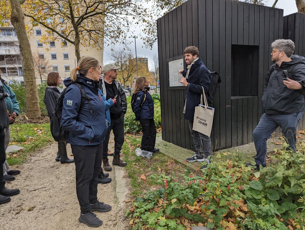 Someone presenting to a group in a garden space outdoors

