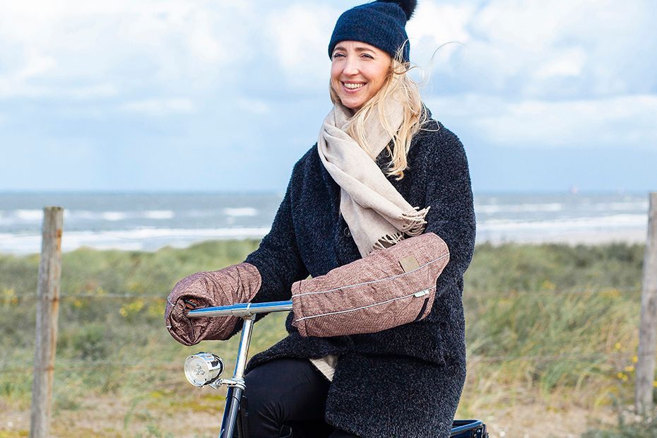 Woman cycling in nature with handlebar covers on her bike