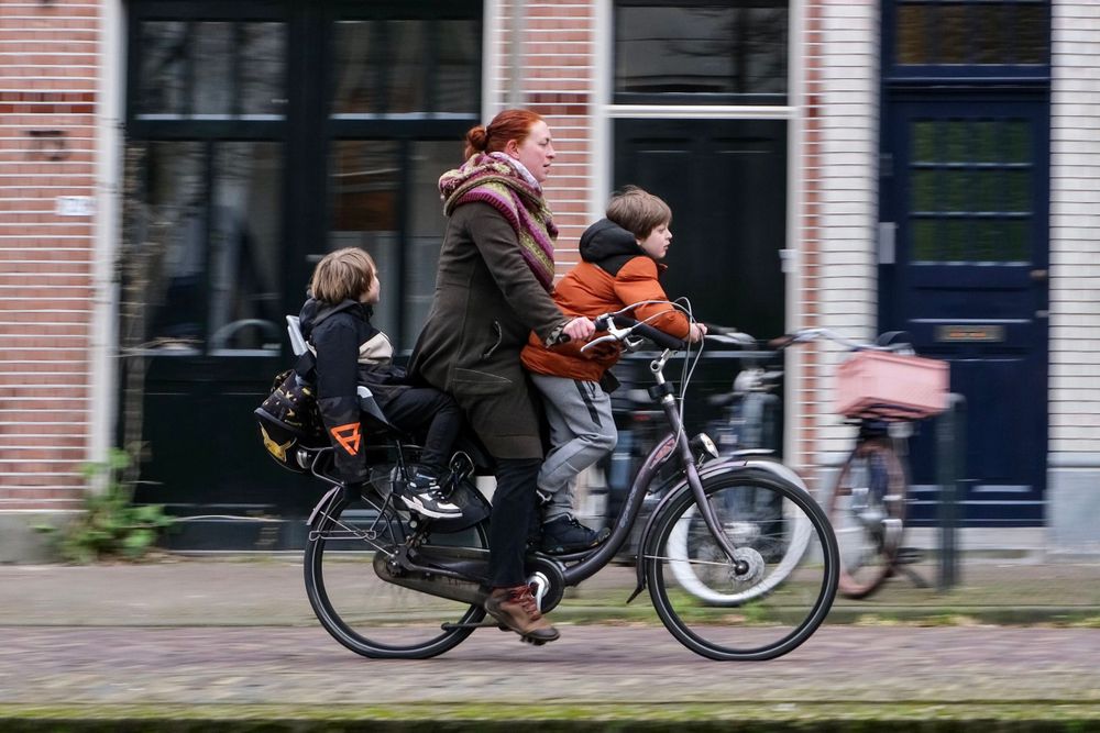 Women cycling with two kids on the bike