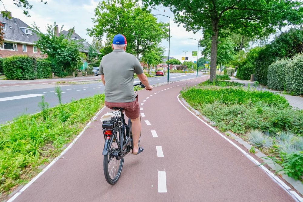 People riding along green cycle path