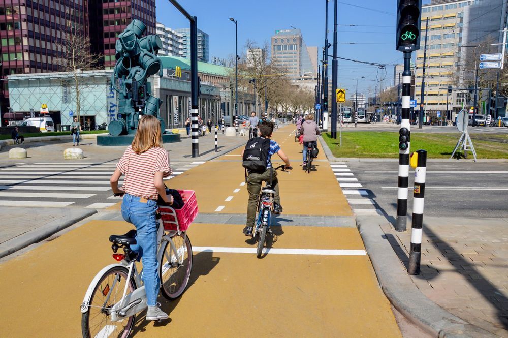 Young people cycling along a yellow cycle path at an intersection