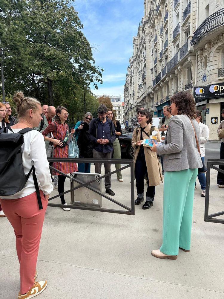 group of people standing next to car-free street barrier