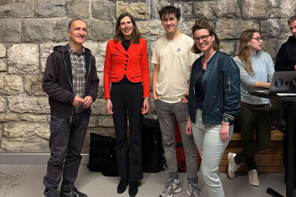 Four people smiling towards camera for group photo