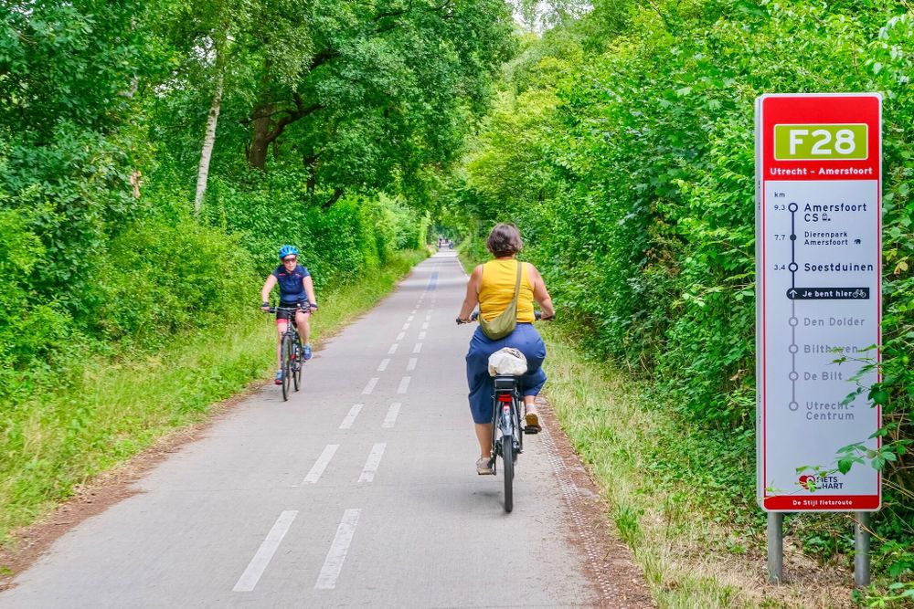 People riding along green cycle path