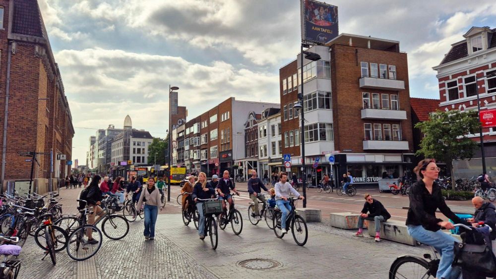 Street full with bikes, pedestrians and a couple of busses