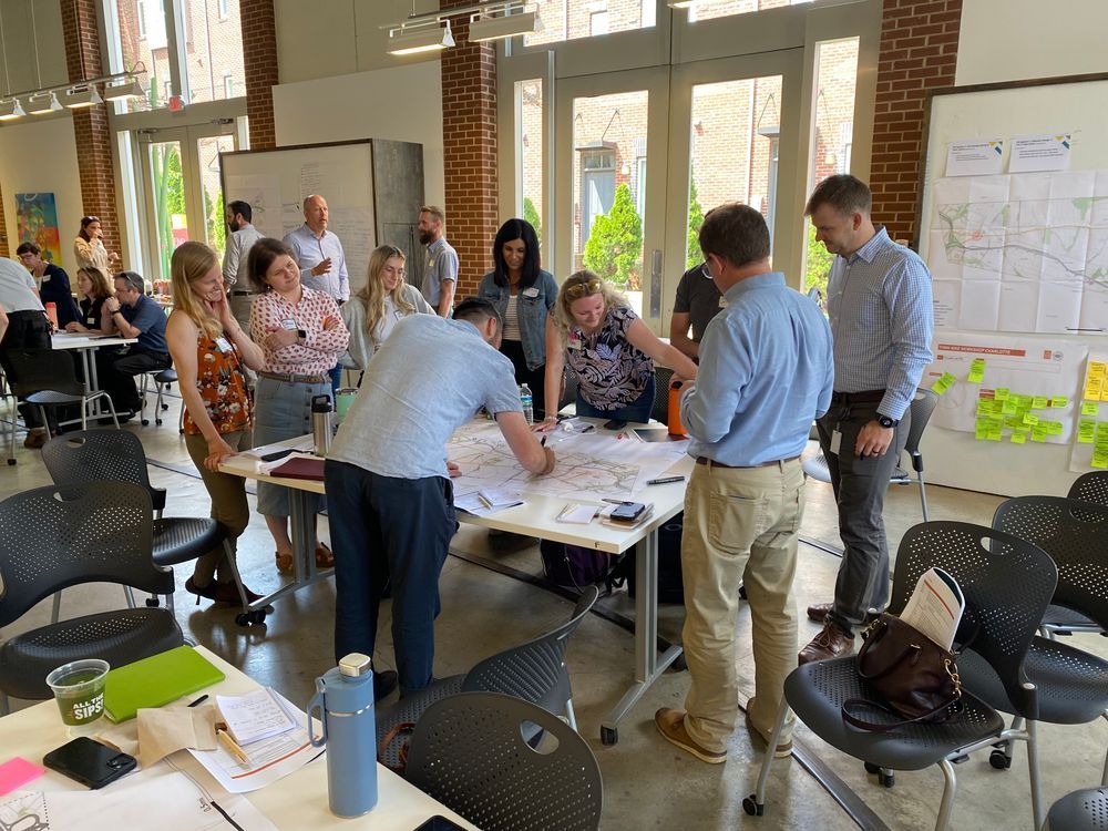 People working around a table covered in plans and paper