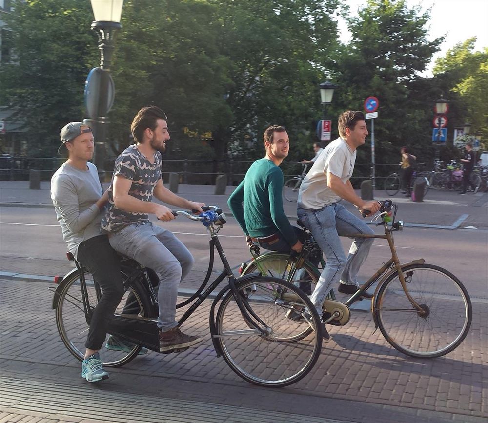 Two friends riding on the back of bikes
