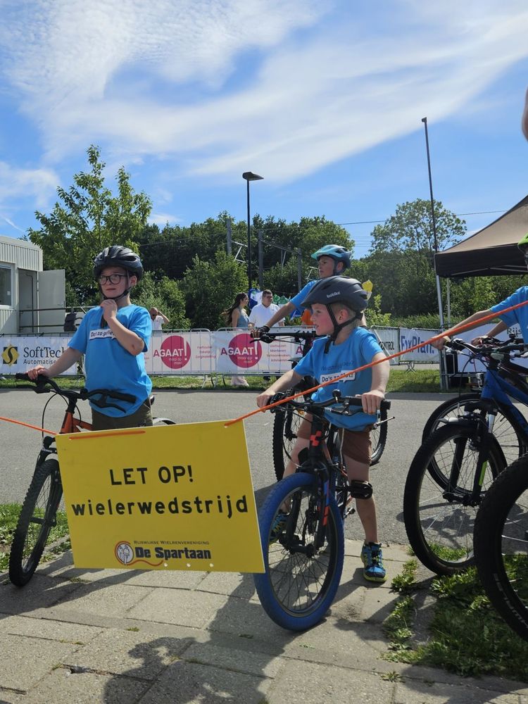 Kids riding around a circuit wearing matching blue t-shirts