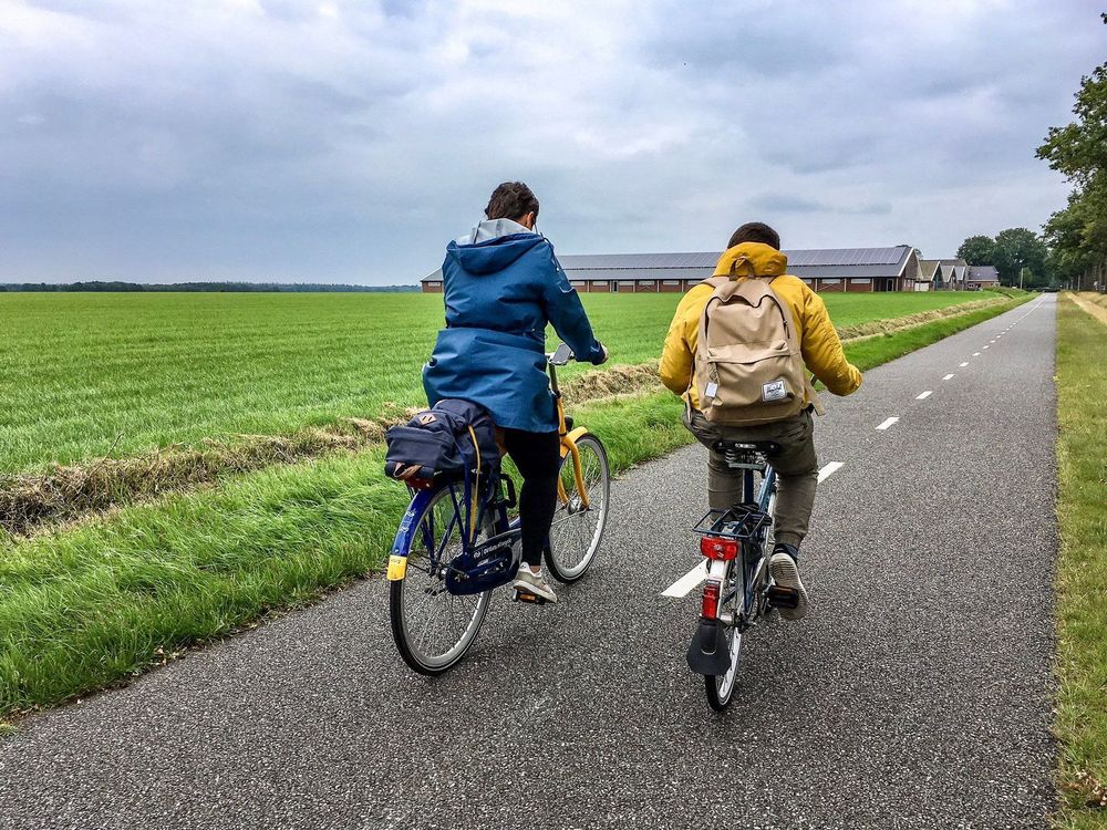 Two people riding along a countryside bike lane