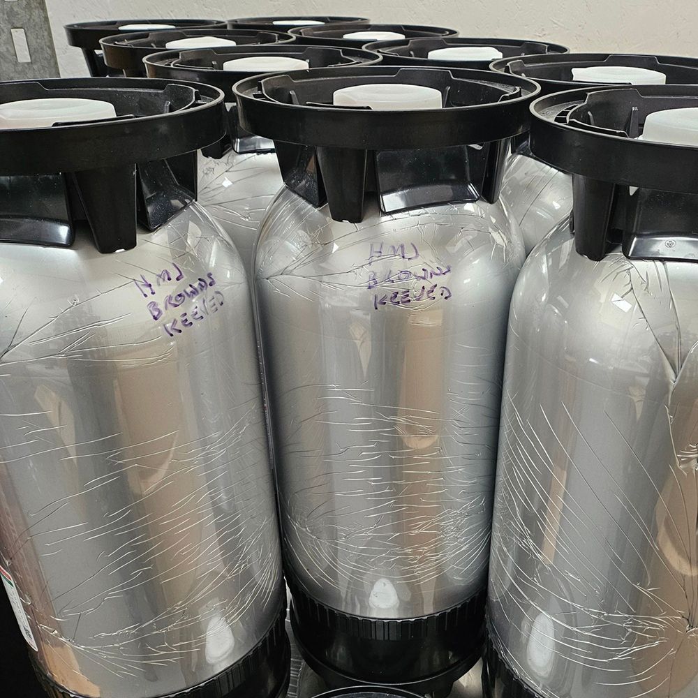 A stack of polykegs (bag in keg) with handwriting on the keg: HMJ Browns Keeved.