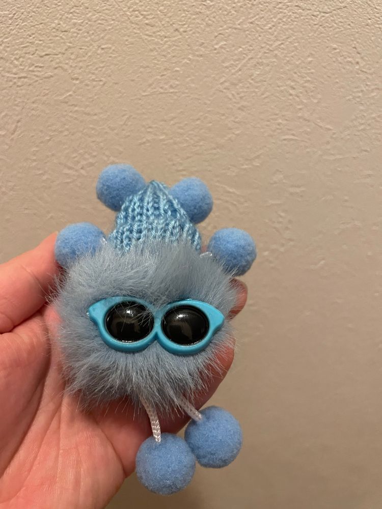 水色の帽子とサングラスをかけた水色ぽいマスコット。もふもふしている。