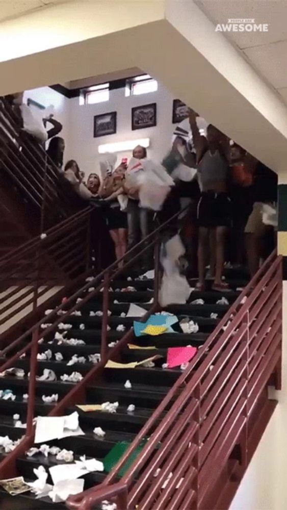 a bunch of people are standing on a set of stairs that are covered in paper