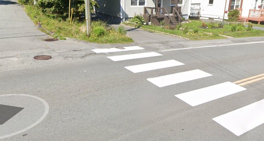 It's a crosswalk on Herring Cove Rd, but it starts at a lamp post. There was a part of a sidewalk that just fades into the street, with no defined corner separating the sidewalk where it meets two intersecting roads.