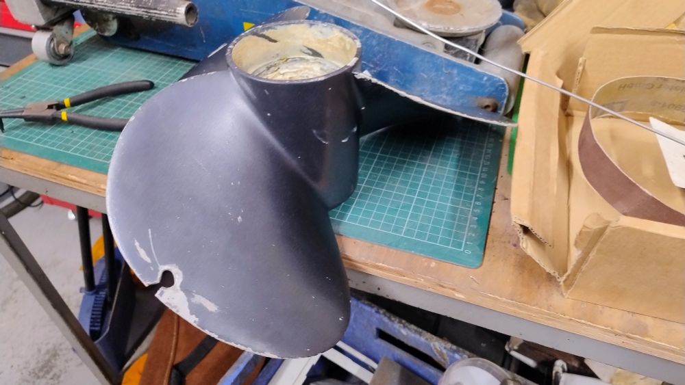 A boat propeller with very obvious damage where a chunk is missing.