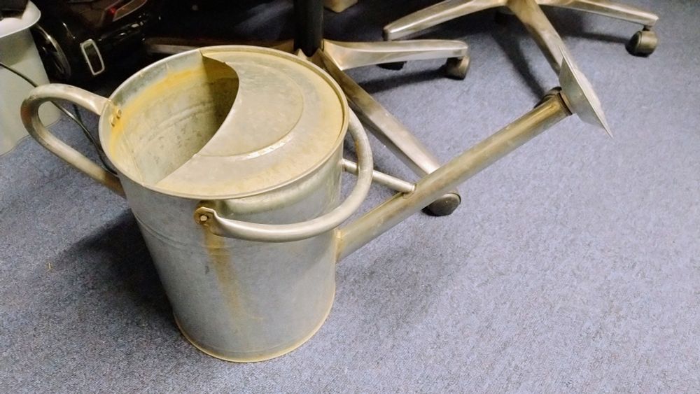A galvanized metal watering can.