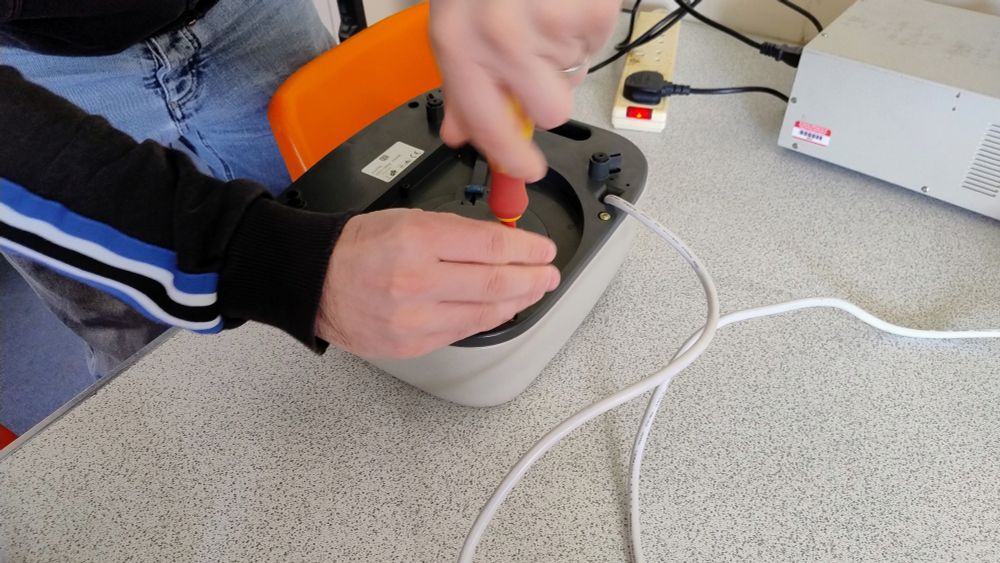 A fan heater upturned and about to be dismantled.