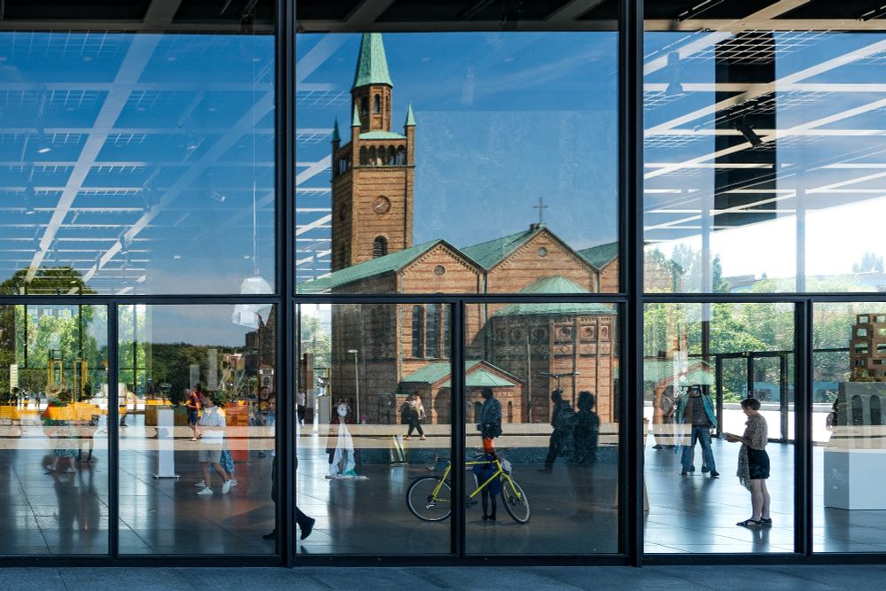 Windows of the New National Gallery with a view inside and reflection of the surroundings 